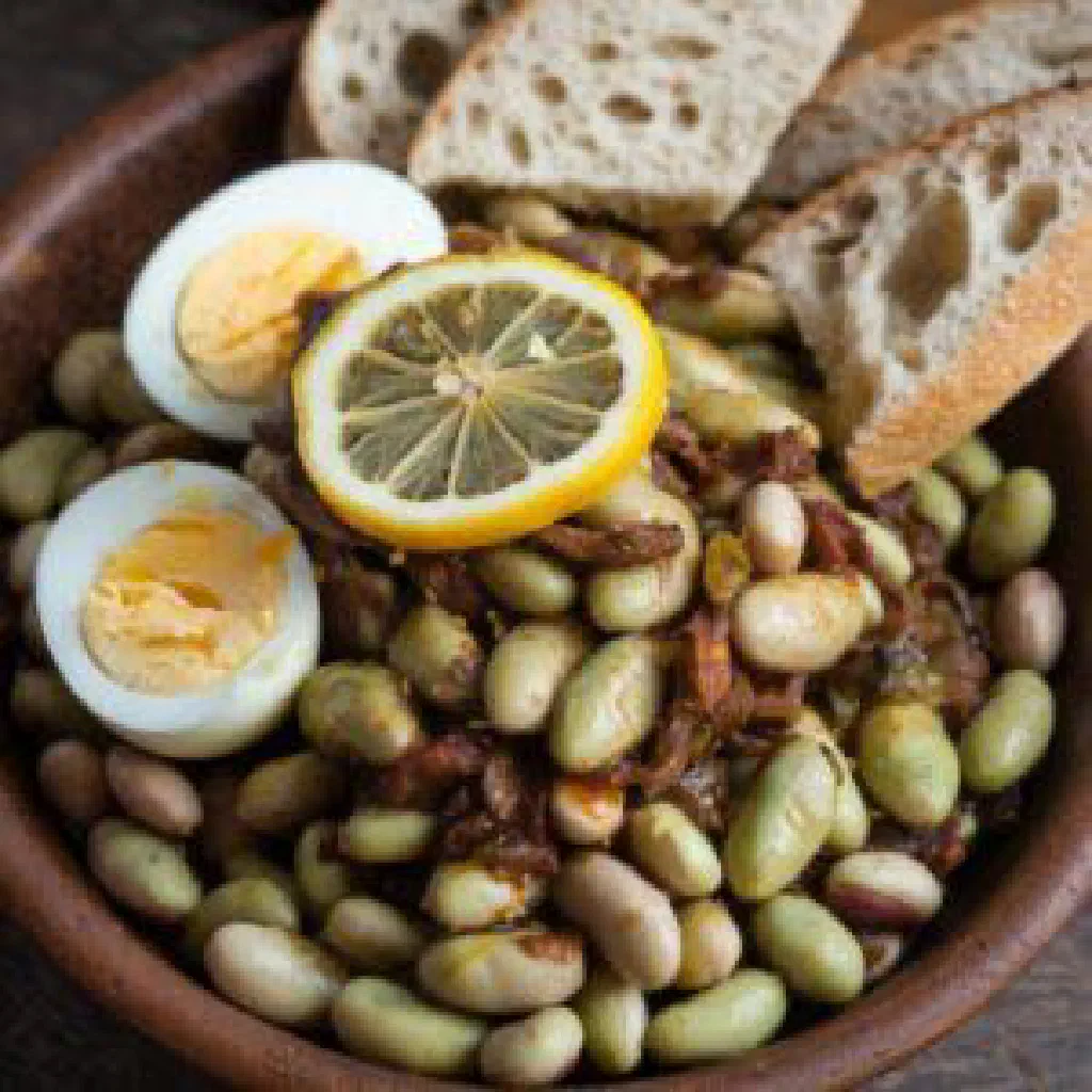 Bowl of foul medames with olive oil, cumin and fresh parsley