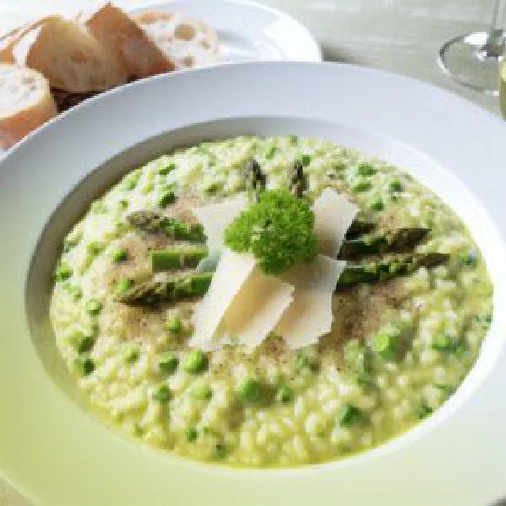 Creamy asparagus risotto topped with fresh herbs and parmesan