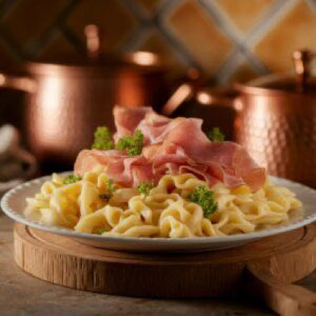 Creamy ham pasta in a cream sauce garnished with fresh chives