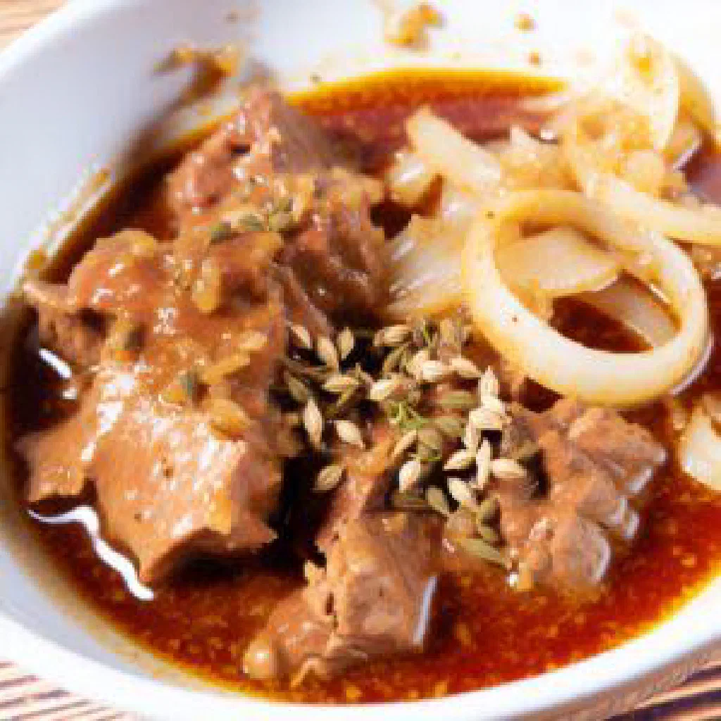 A bowl of Austrian Saftgulasch with tender beef in a rich paprika onion sauce
