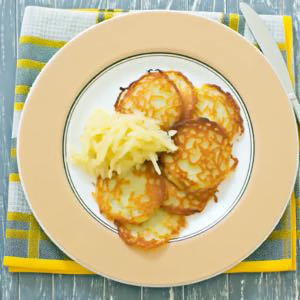 Golden fried Belarusian bulba potato cakes with sour cream and fresh herbs