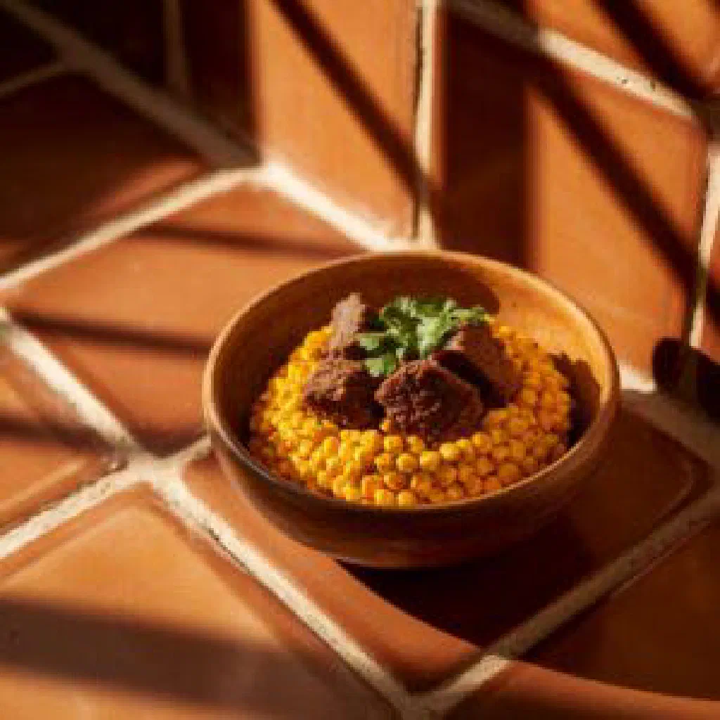K'allu with tender beef, potatoes and carrots garnished with fresh herbs