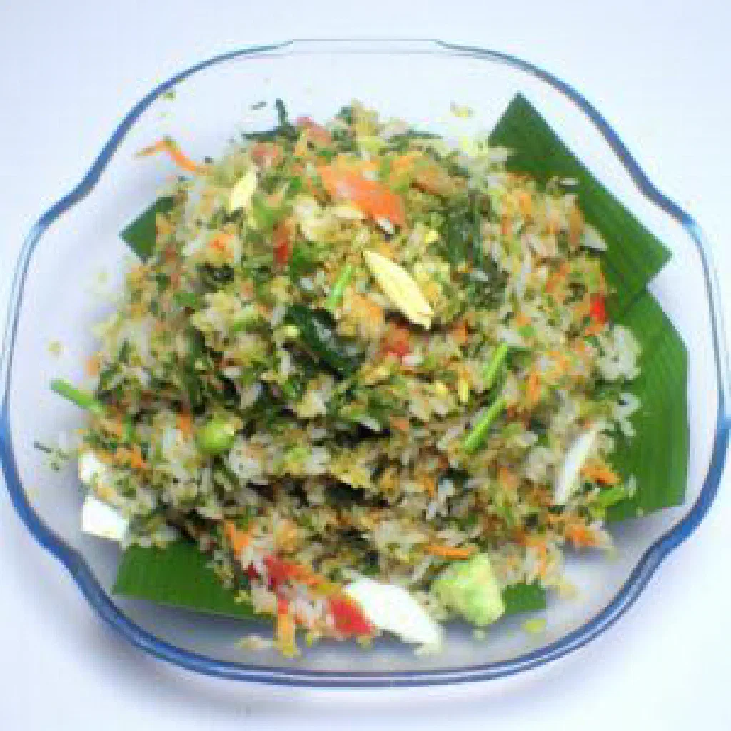 Nasi ulam herbed rice salad garnished with fresh herbs and lime