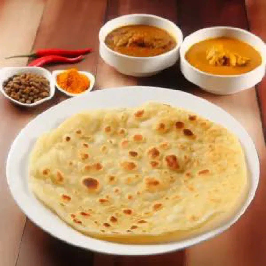 Flaky golden roti canai served with a bowl of curry