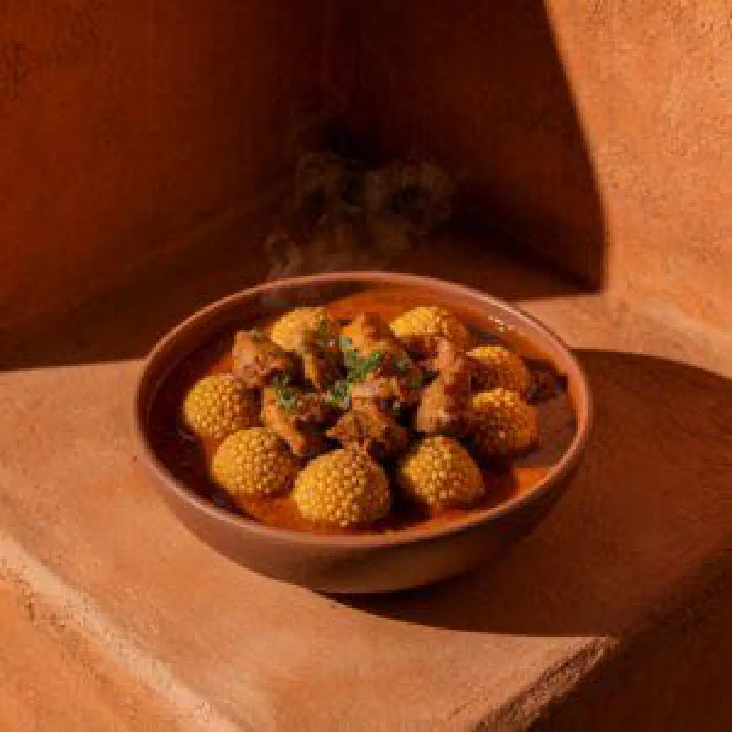 Bowl of klouikloui with pulses, golden onions and fresh herbs