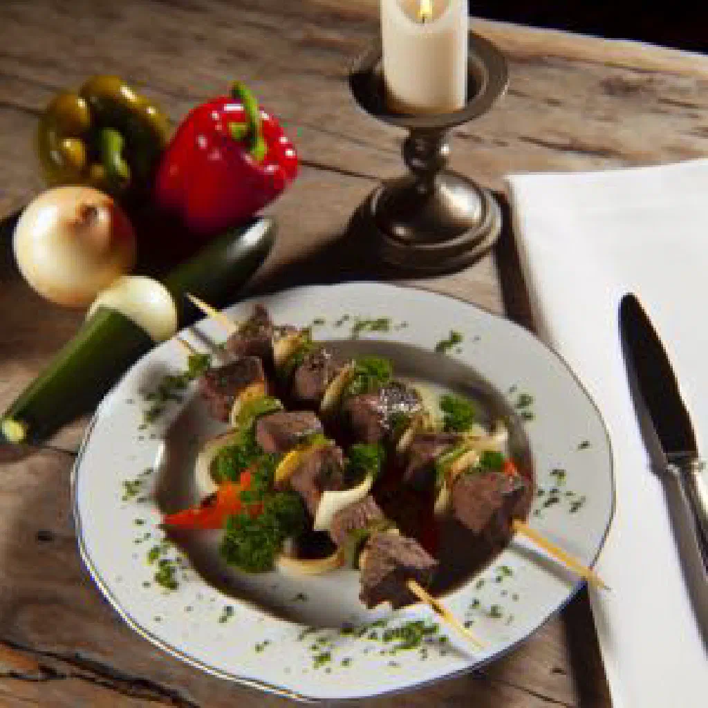 Grilled beef skewers with a spiced marinade, garnished with fresh herbs