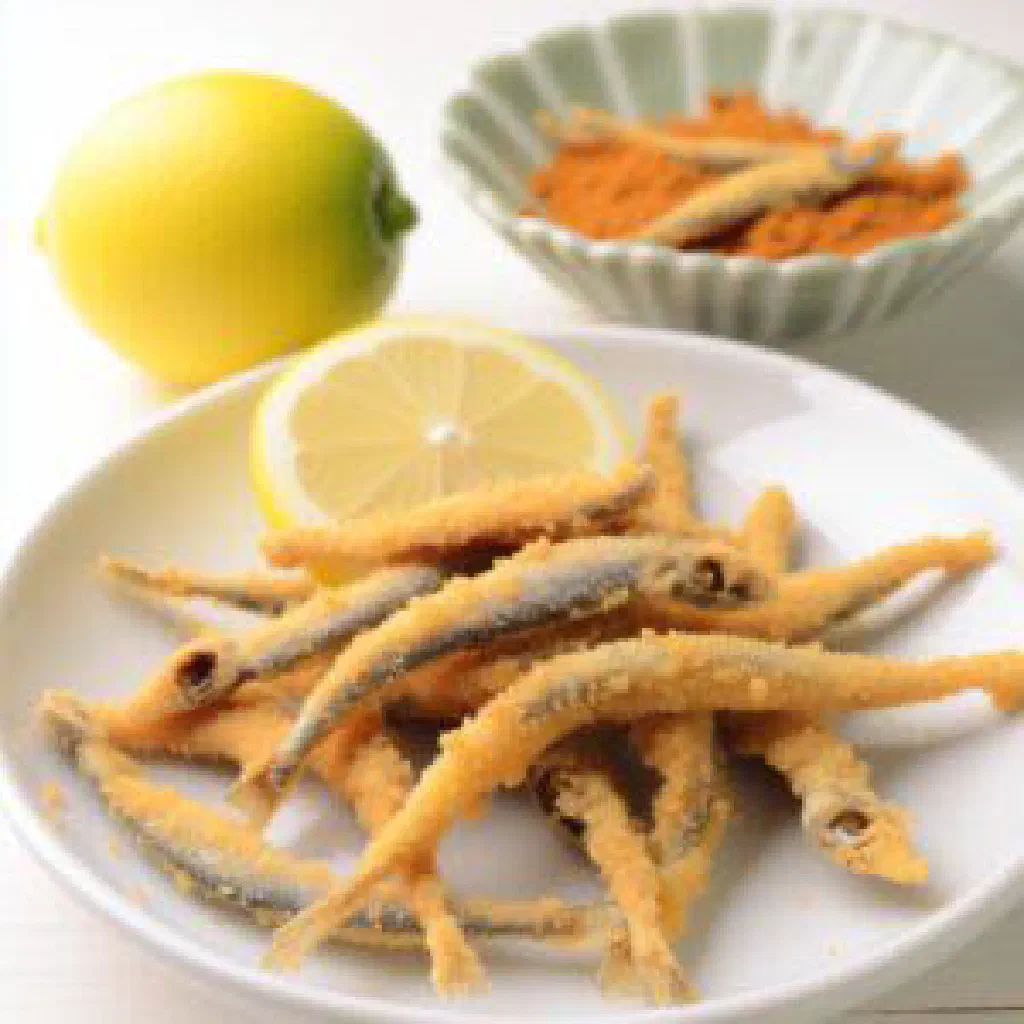 Crispy fried isambaza served with lemon wedges and fresh herbs
