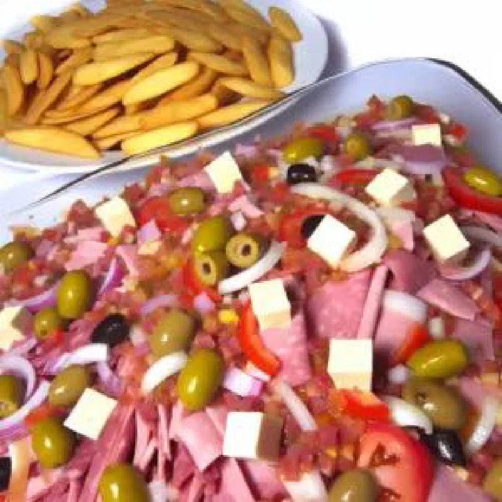 Colourful Chilean pichanga platter with sliced sausage, cheese, olives and vegetables