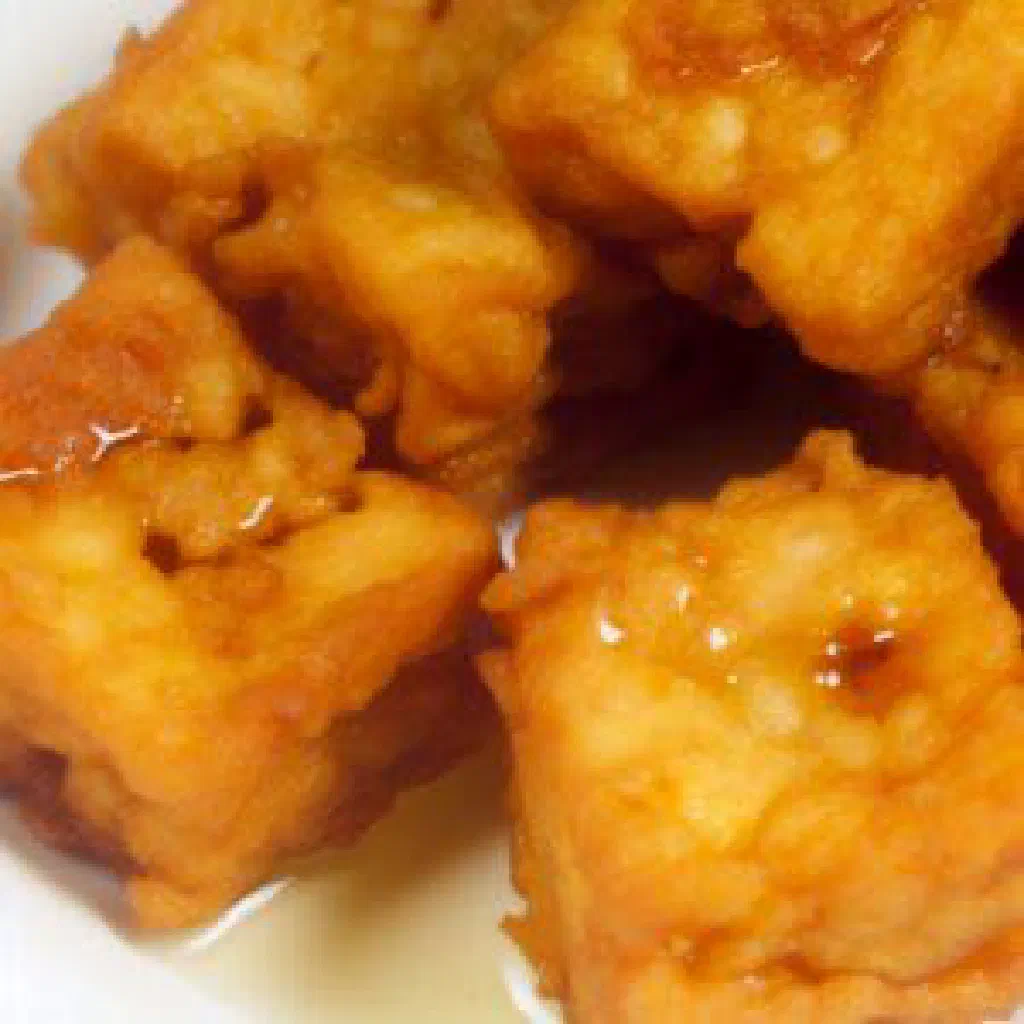 Golden pan-fried Jiao Yan cubes garnished with fresh coriander and sesame