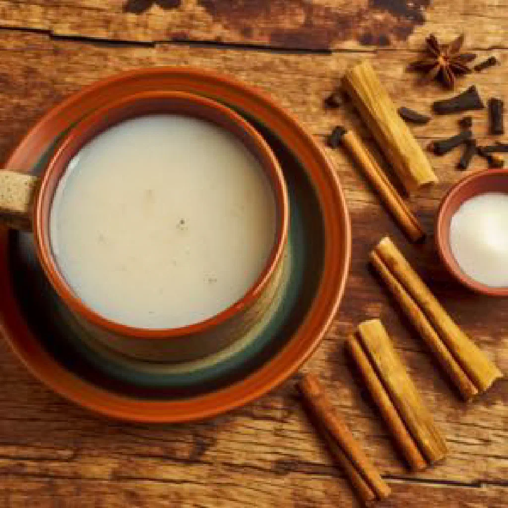 Glass of creamy fermented rice masato garnished with a cinnamon stick
