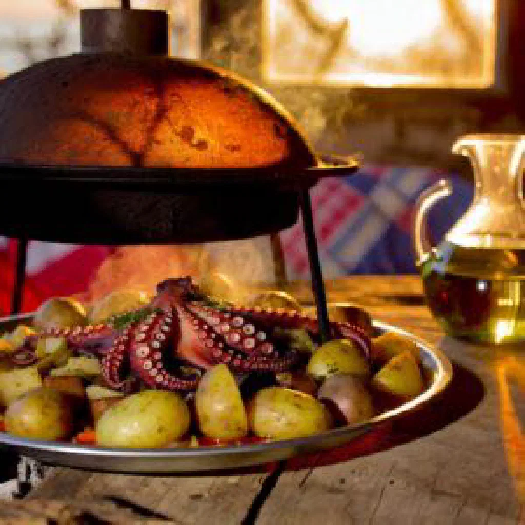 Tender octopus with potatoes and vegetables cooked under a peka bell
