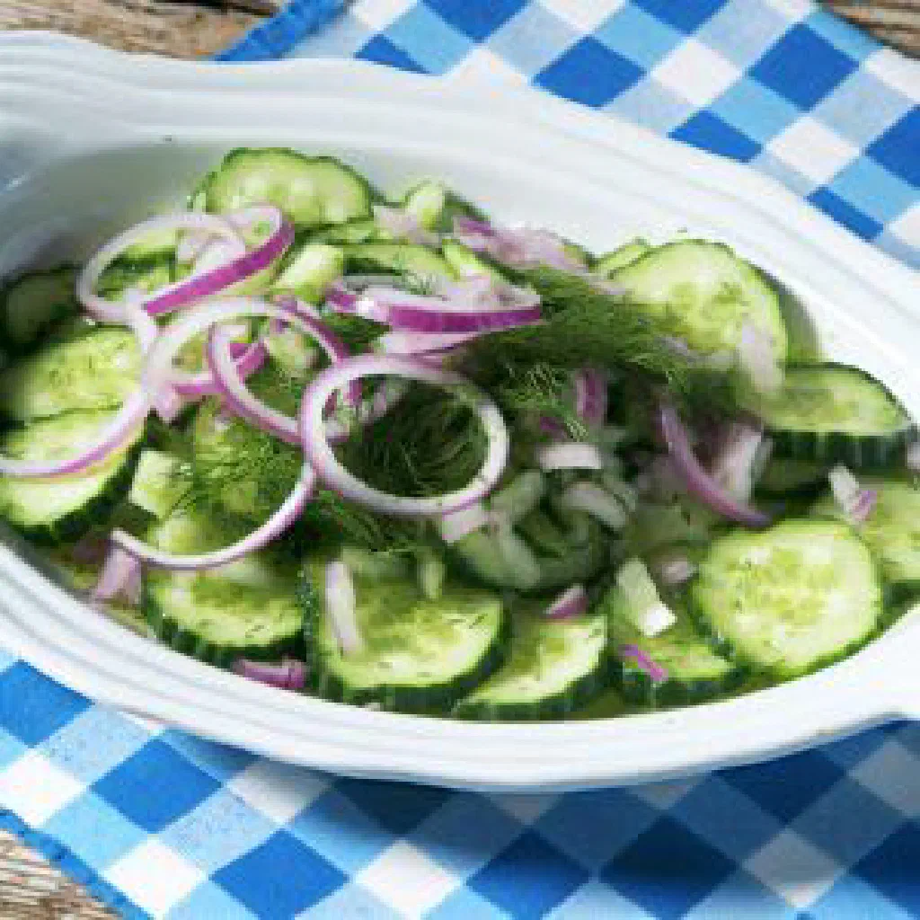 Bowl of Croatian cucumber salad with red onion and fresh herbs