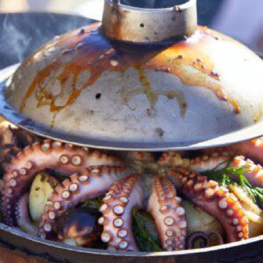 Tender octopus and potatoes cooked peka-style with herbs and olive oil