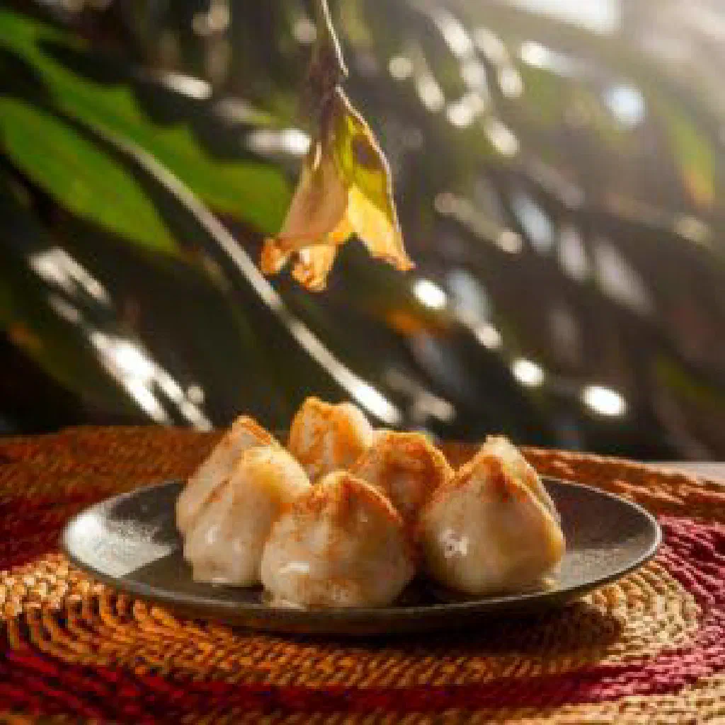 Golden guava-filled pastries dusted with icing sugar on a plate