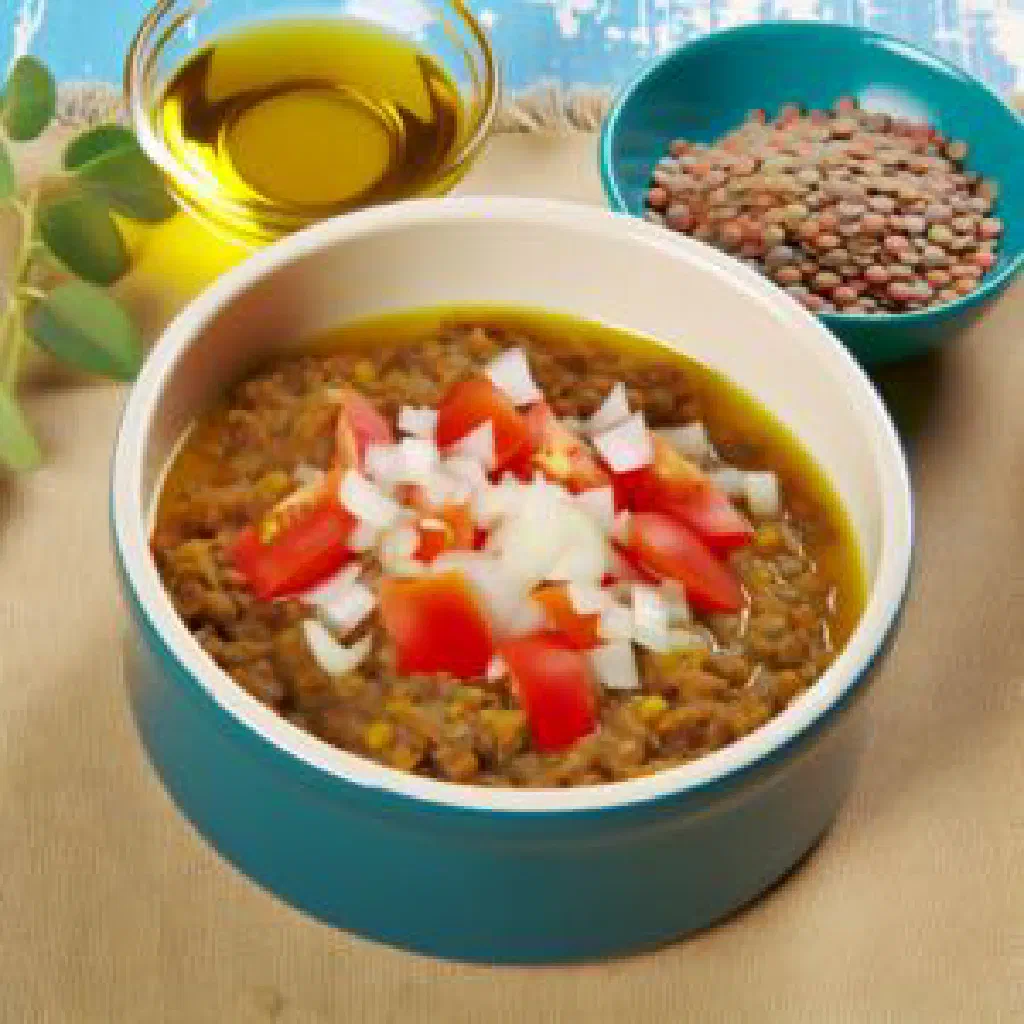 A bowl of Cypriot fakes lentil soup garnished with olive oil and lemon