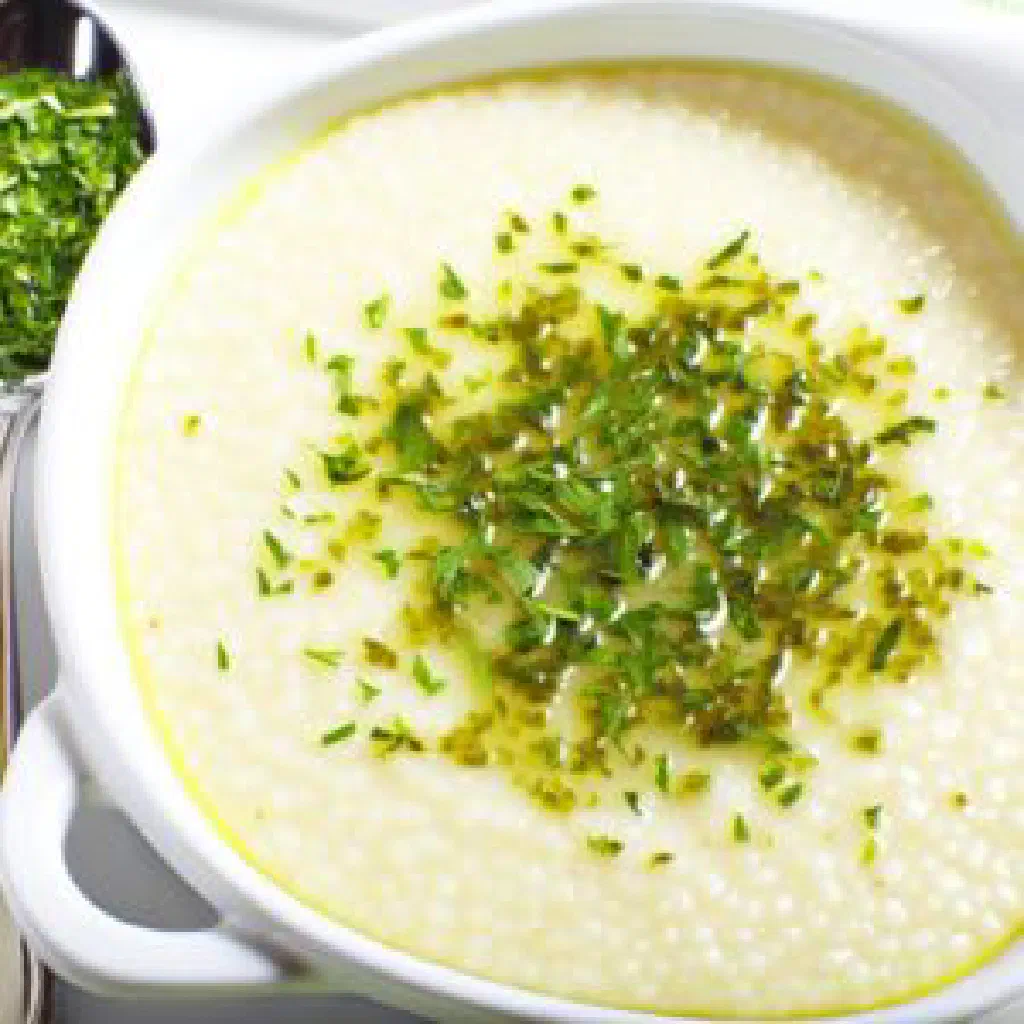 Creamy Egyptian eish fino semolina dish garnished with fresh herbs
