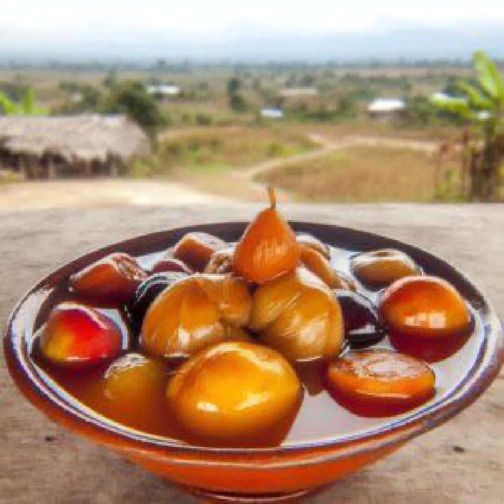 Fresh fruit pieces glistening in honey syrup served in a small bowl