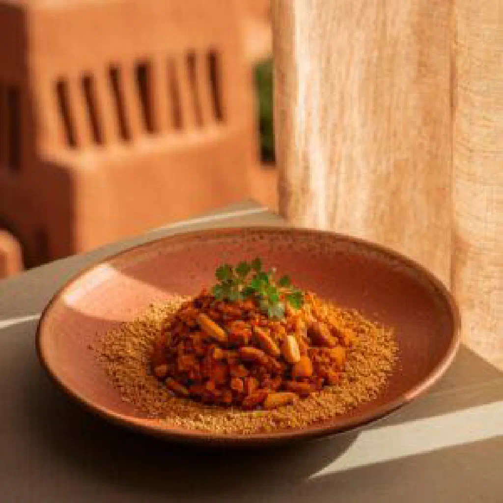 A steaming bowl of Gambian ebbeh with fish in a creamy peanut sauce