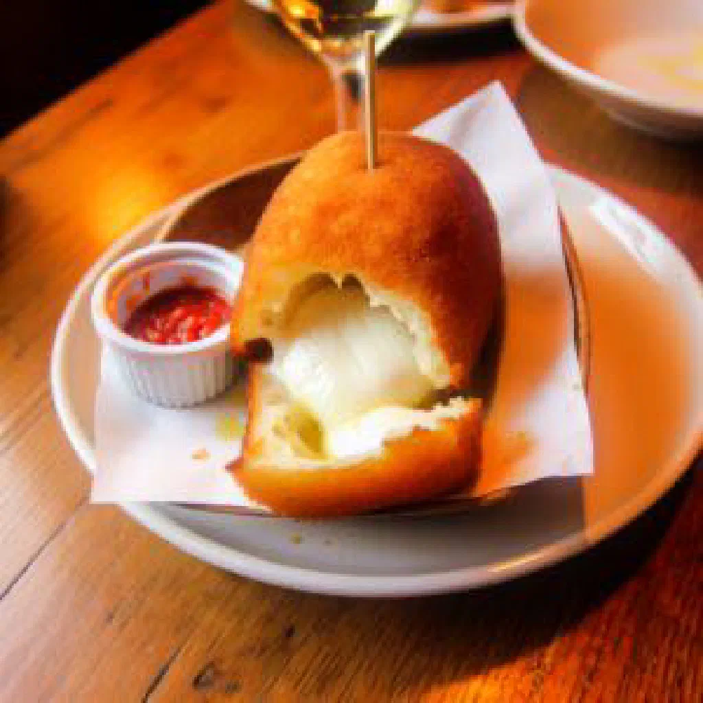 Golden fried mozzarella in carrozza cut into triangles on a plate