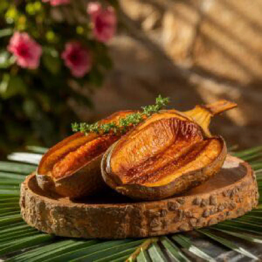 Roasted breadfruit sliced open, golden and tender, garnished with fresh herbs