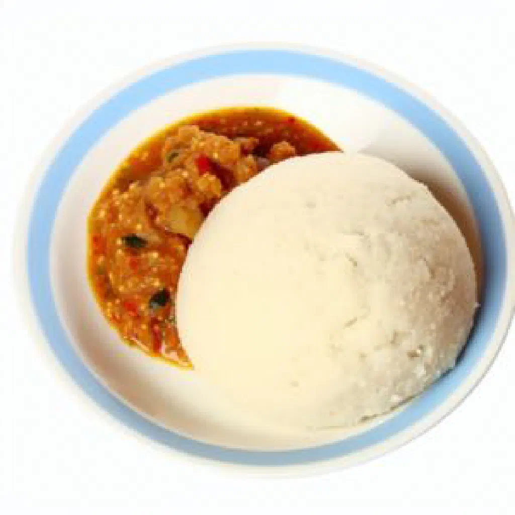 Firm block of dark millet ugali on a plate with a vegetable stew