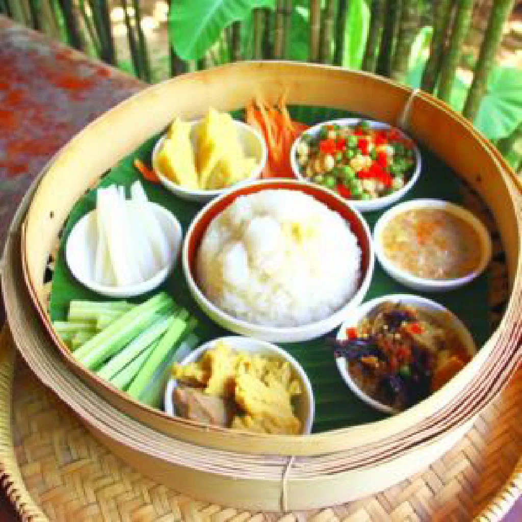 A bowl of Pa Khao rice with vegetables and fresh herbs