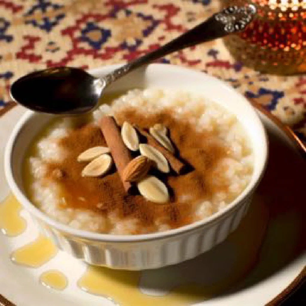 Creamy Lebanese rice pudding topped with chopped pistachios and cinnamon