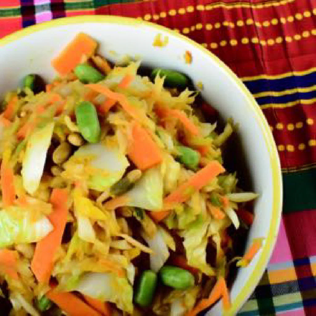 Colourful bowl of Achard Legioma pickled vegetables garnished with fresh herbs