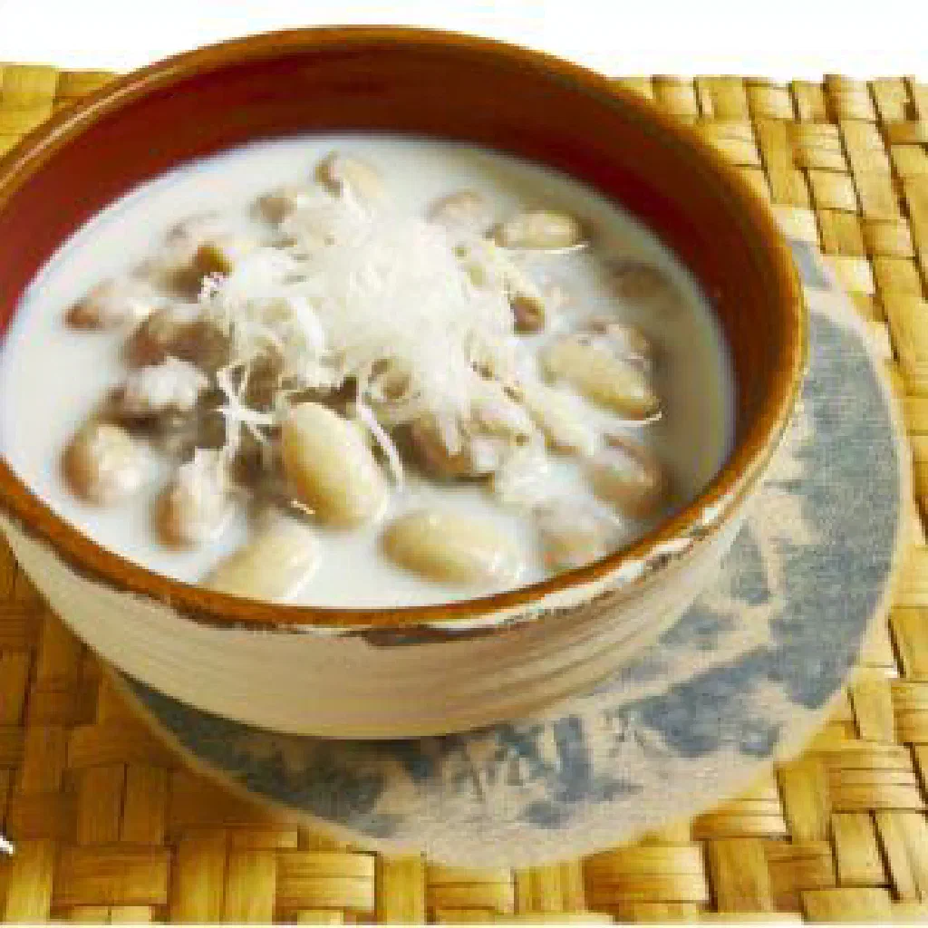 Green beans simmered in coconut milk, garnished with fresh herbs