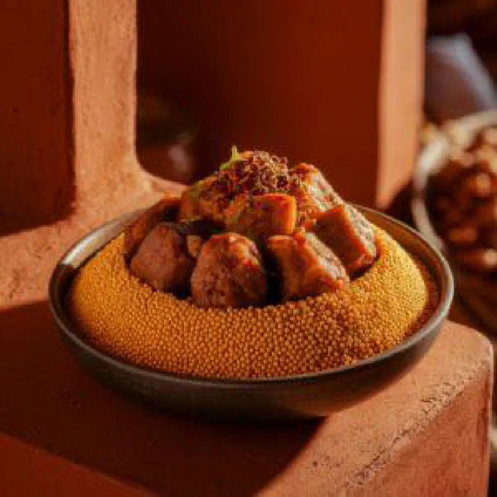 Bowl of Malian koudé with roasted peanuts, carrots and peppers in a thick sauce