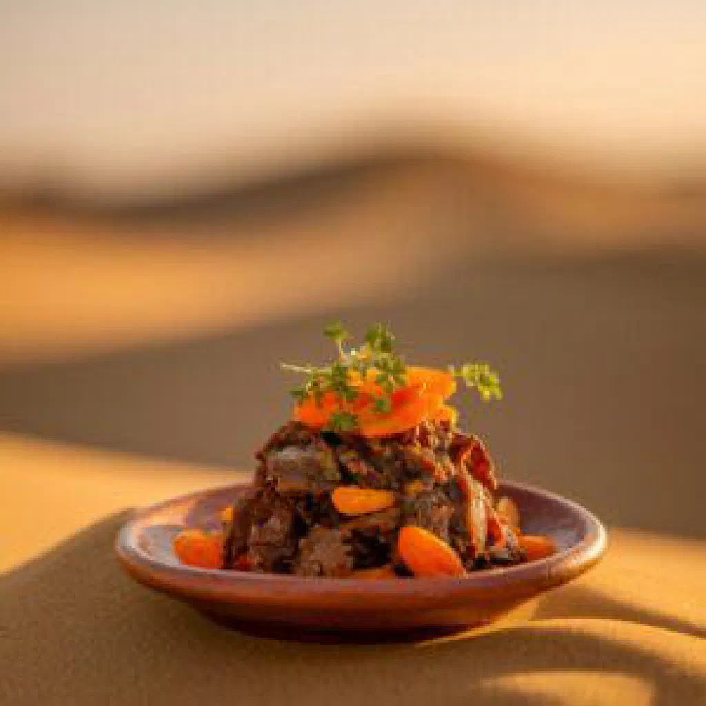 A steaming pot of daraba with rice, meat and tomatoes garnished with fresh coriander