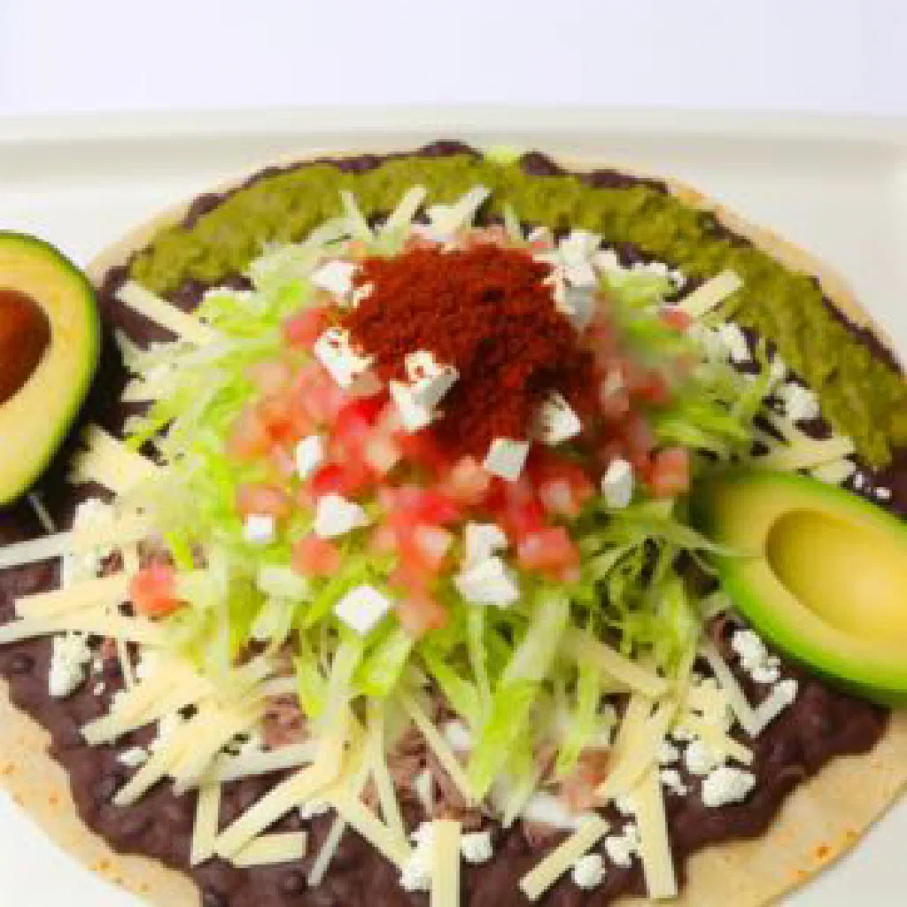 Crispy Oaxacan tlayuda topped with black beans, cheese and avocado