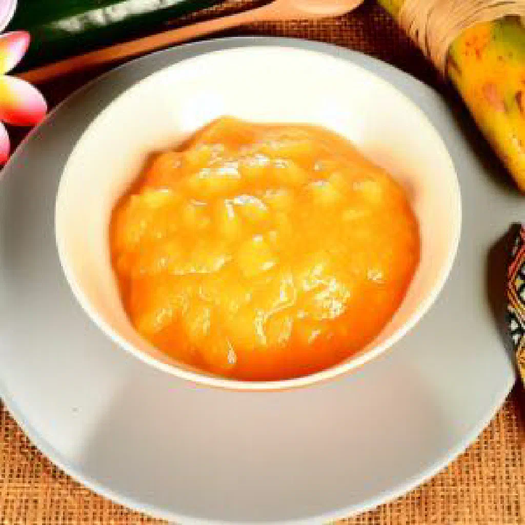 Golden pandanus fruit pudding in a small bowl topped with toasted coconut