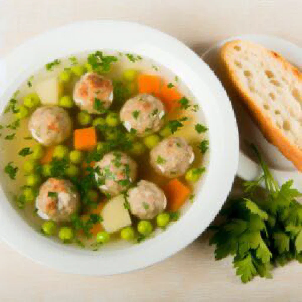 Bowl of Moldovan meatball soup with carrots, potatoes and fresh dill