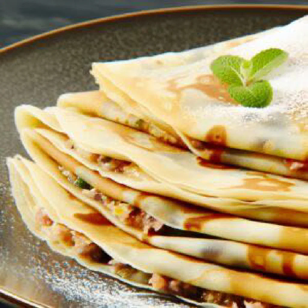 Golden-brown Moroccan mahjouba stuffed crêpes folded and served