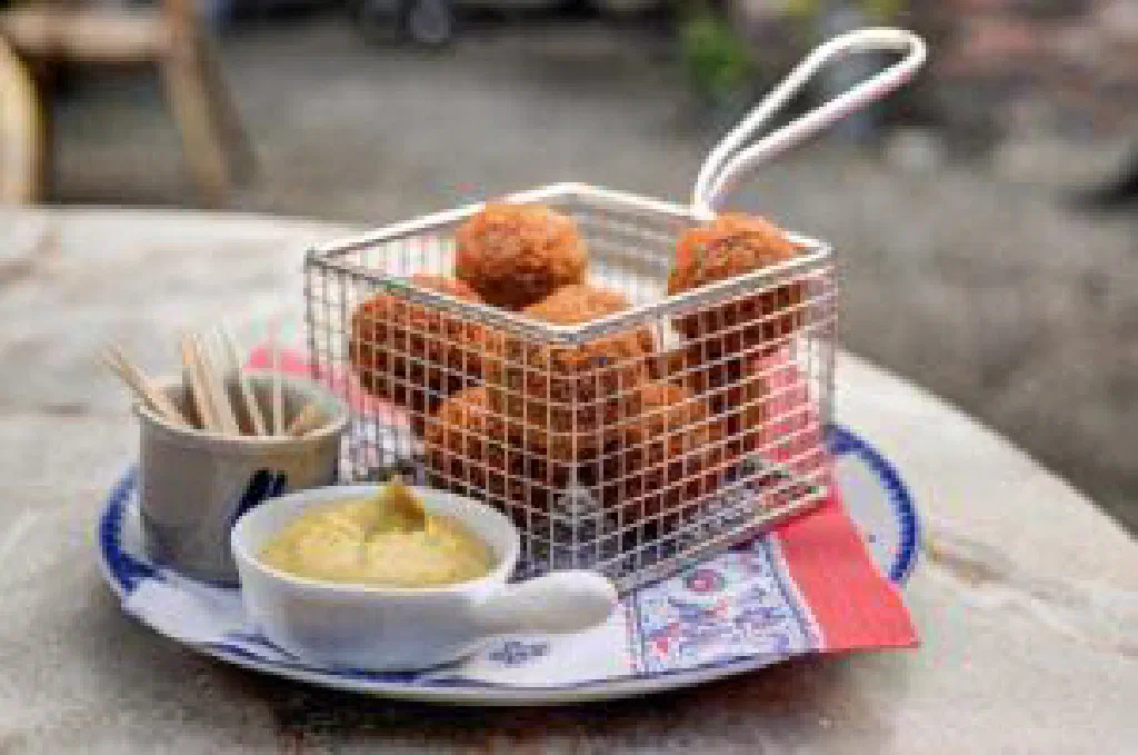 Golden, crispy bitterballen served with mustard for dipping