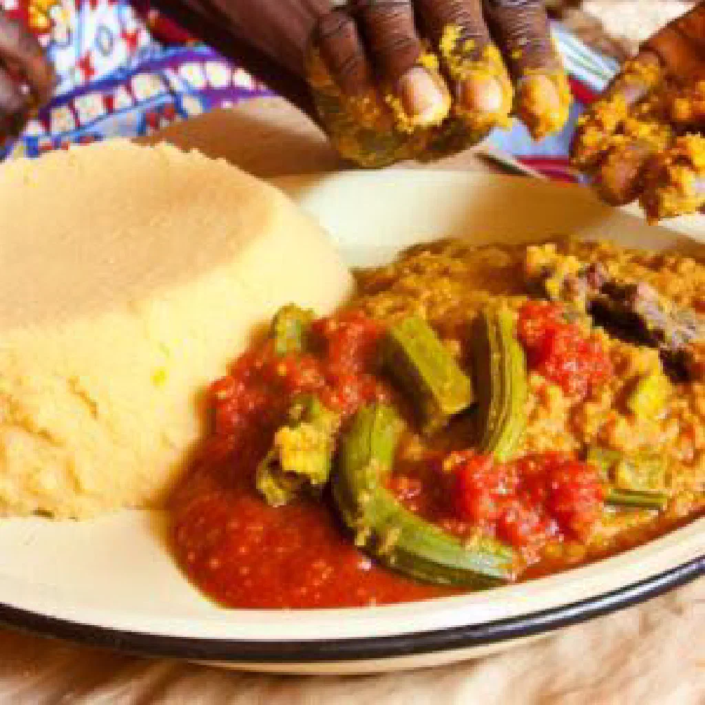 A bowl of smooth millet tô served with a rich vegetable sauce
