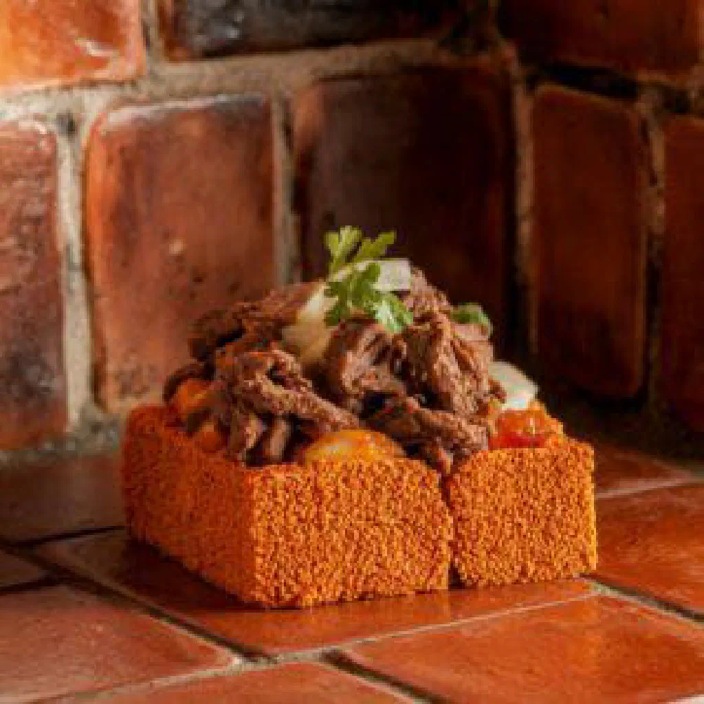 Golden baked Ka'í Ladrillo made with cornmeal, cheese and fresh herbs