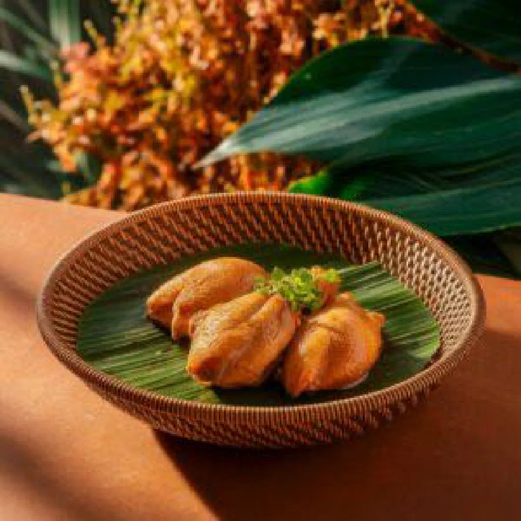 Bowl of Binakol chicken soup with coconut and fresh herbs