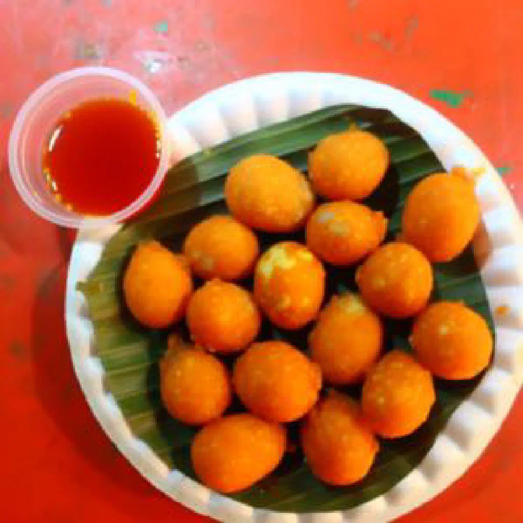 Bright orange battered deep-fried eggs served with a spicy dipping sauce