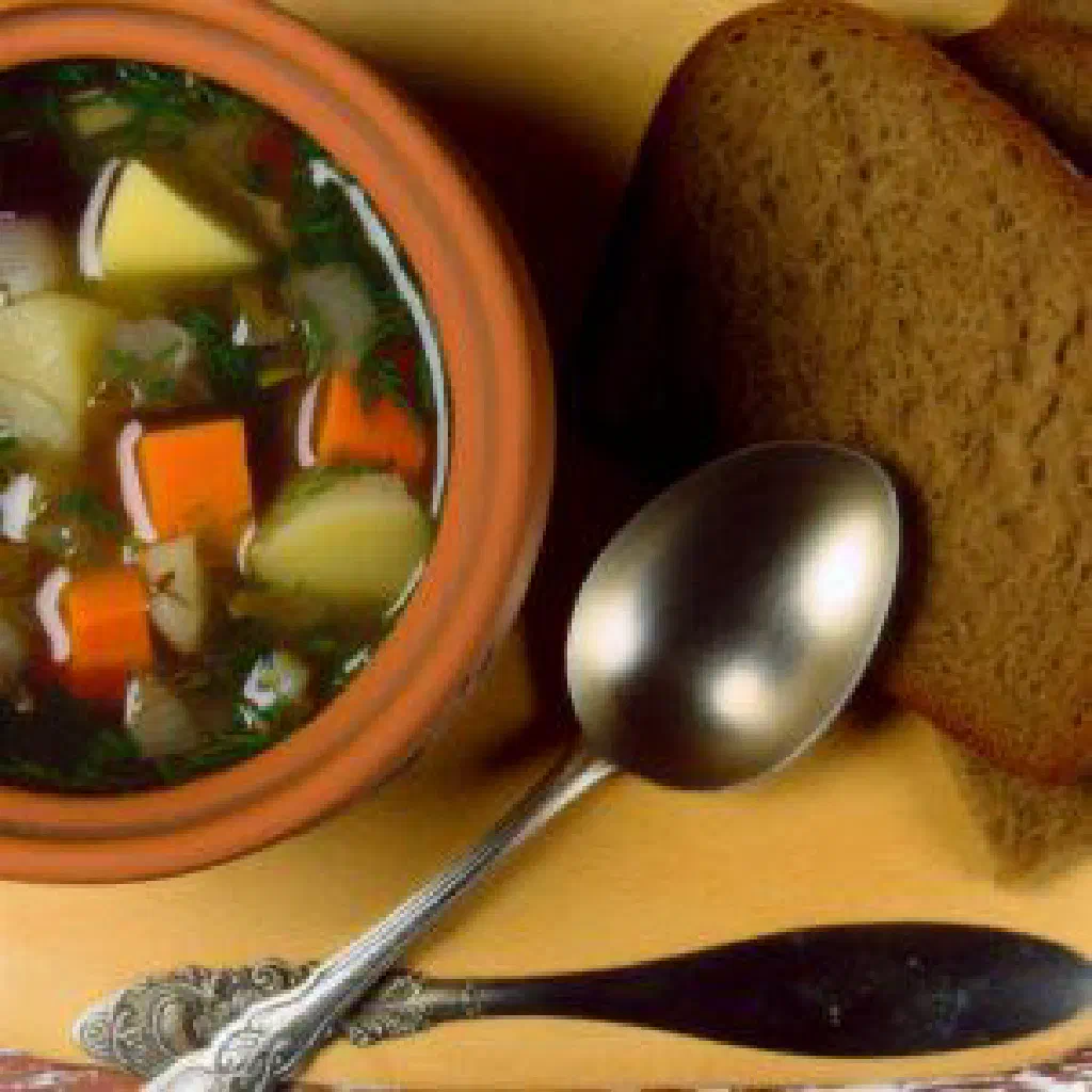 Bowl of chilled green botvinya soup with herbs and fish