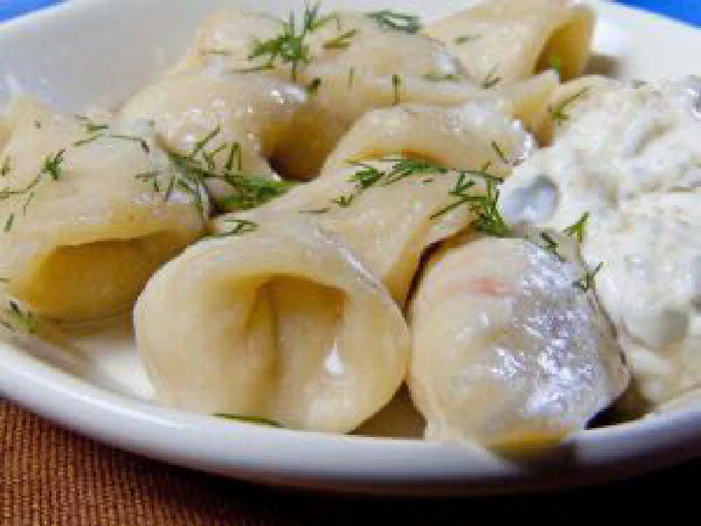 Russian pelmeni dumplings served with sour cream and fresh dill