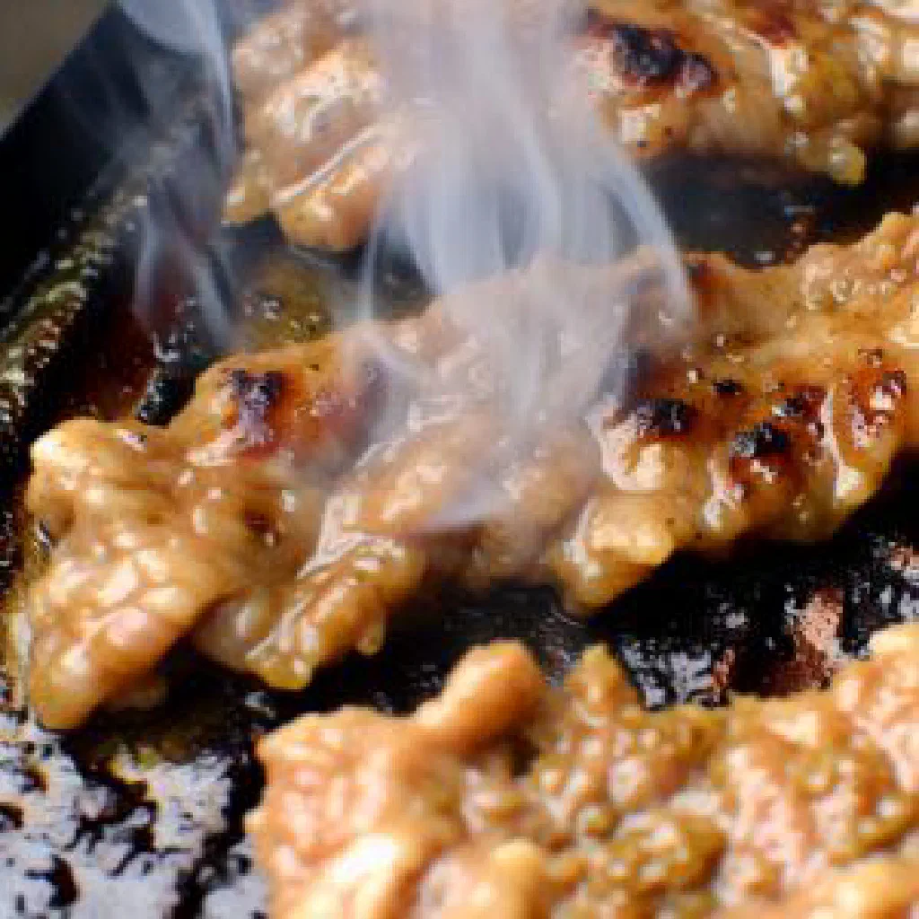 Crispy fried marinated pork pieces garnished with fresh herbs