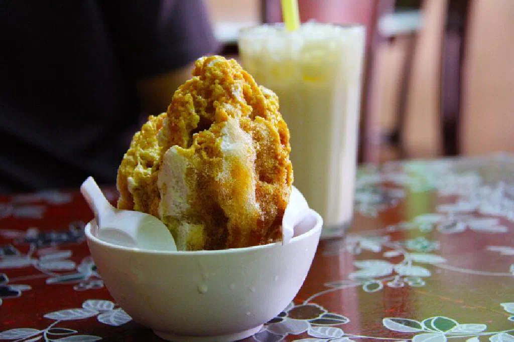 A bowl of chendol with green rice-flour jelly noodles, coconut milk and palm sugar syrup