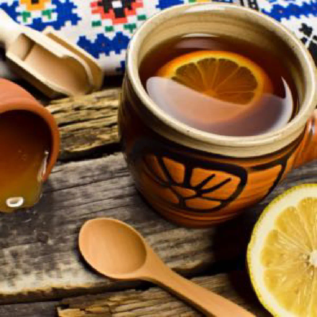 A steaming cup of Karpatský Čaj herbal tea garnished with fresh herbs