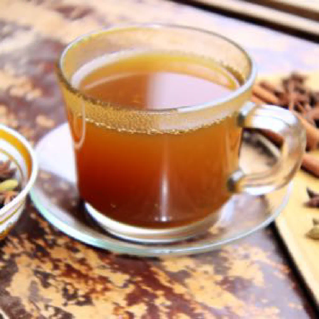 Glass of Somali spiced tea with cinnamon sticks and cloves
