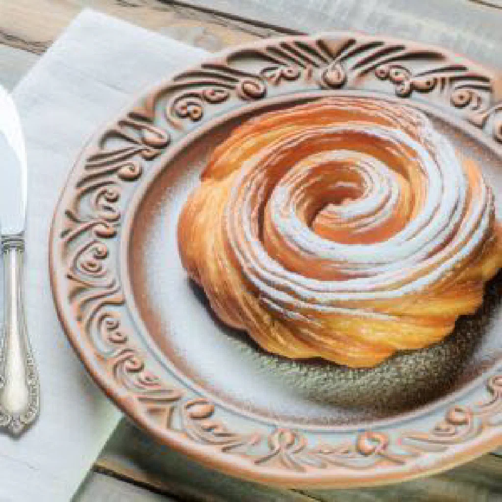 Spiral ensaïmada pastry dusted with icing sugar