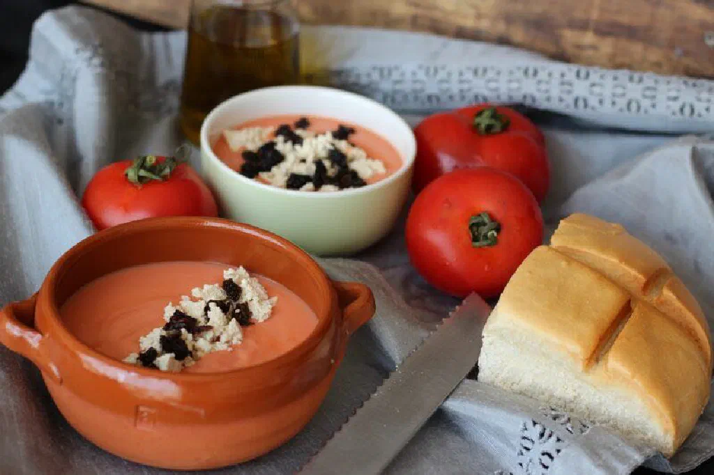 Bowl of creamy salmorejo topped with chopped egg and ham
