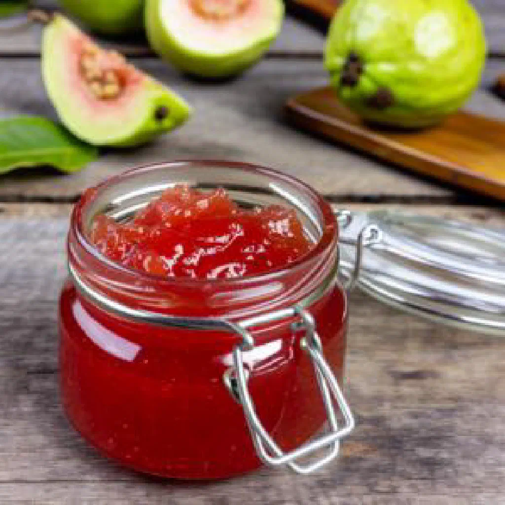 Jars of homemade guava jam with fresh guavas and lemon