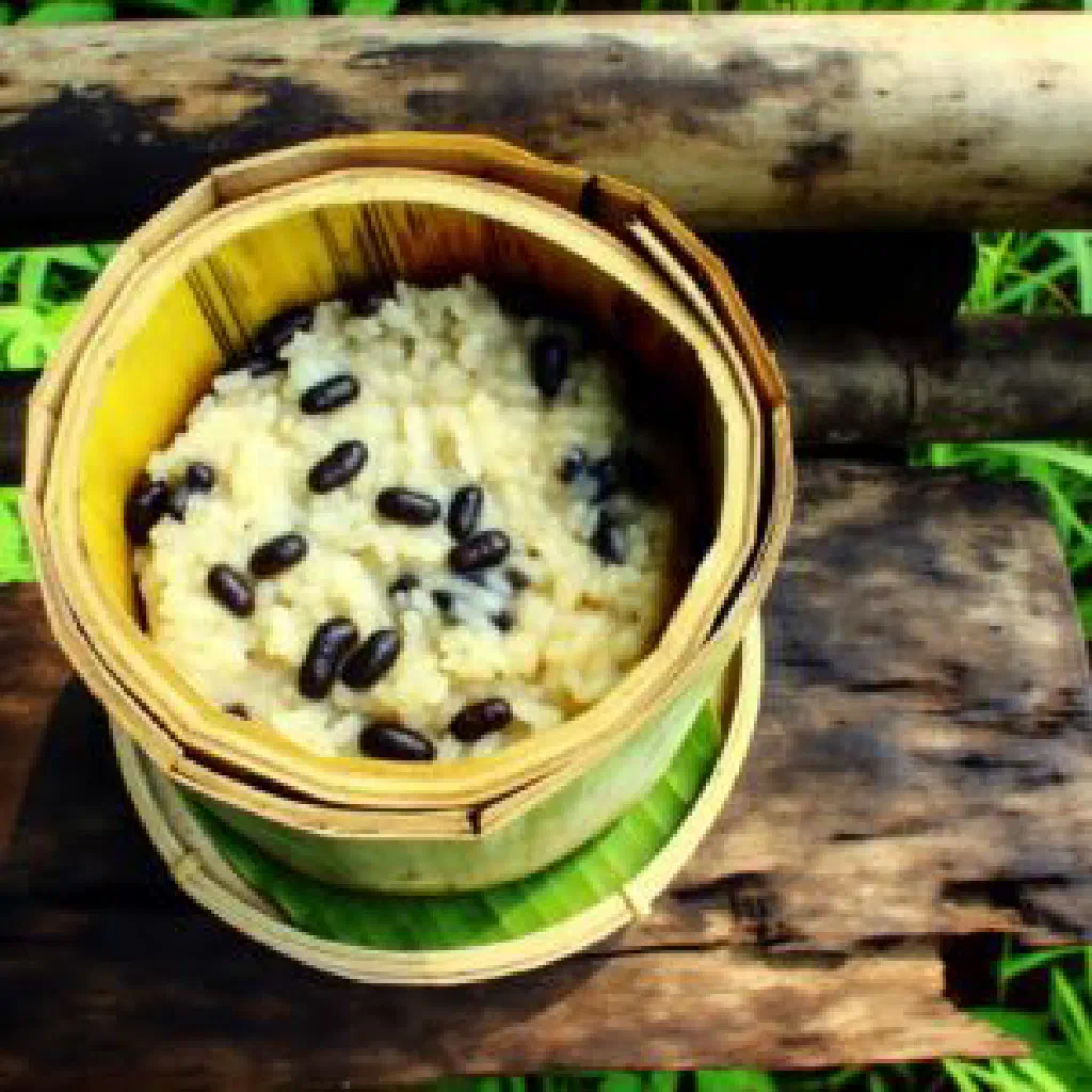 Khao laam sticky rice steamed in bamboo tubes, sliced open to serve